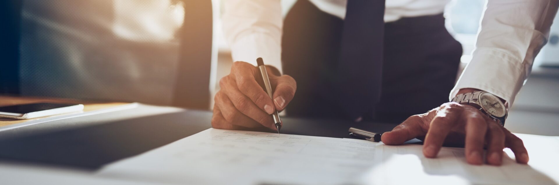 An attorney leans over a desk with a pen