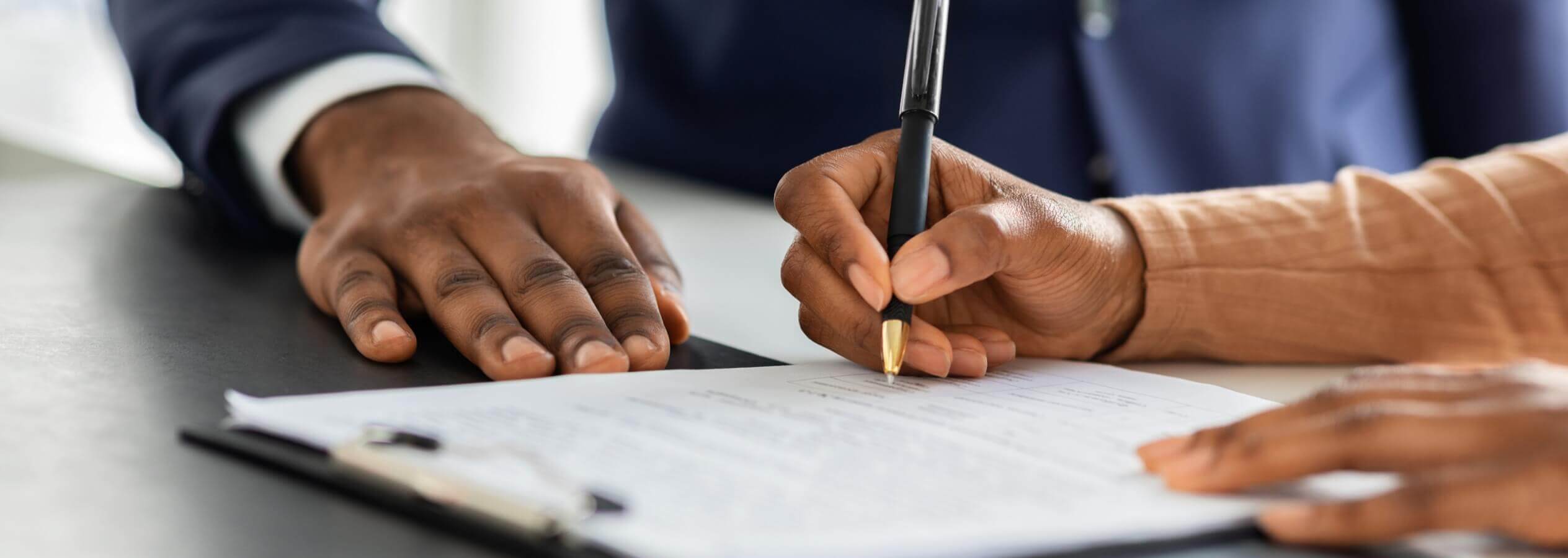 closeup of someone signing a document