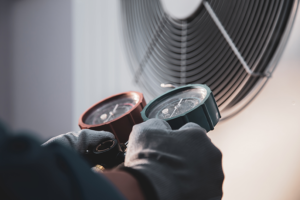 Technician hands holding HVAC inspection equipment.