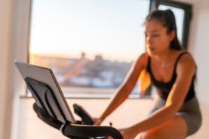 Lady exercising on interactive stationary bicycle.