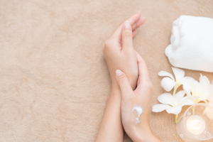 Hands with skin cream in spa setting